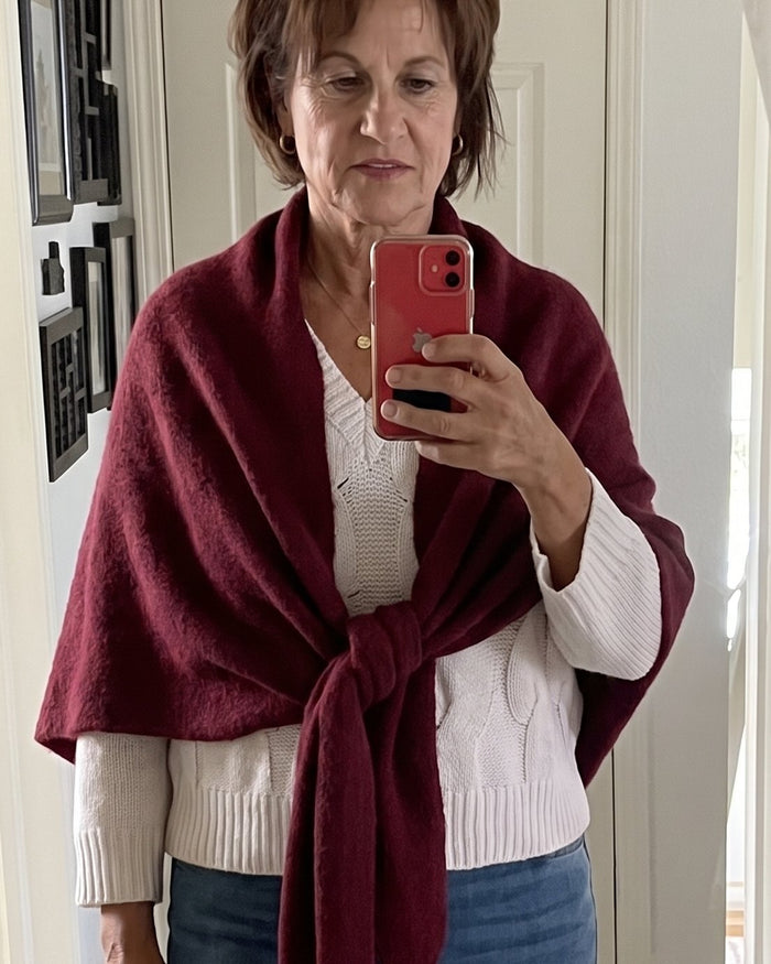 The Fleece Shawl knotted over a white sweater and jeans