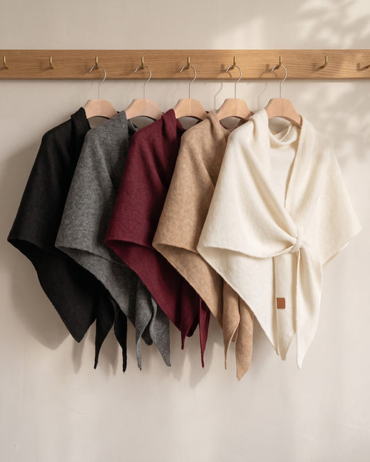 The Fleece Shawl in five colors on an oak rail: black, gray, red, khaki and white