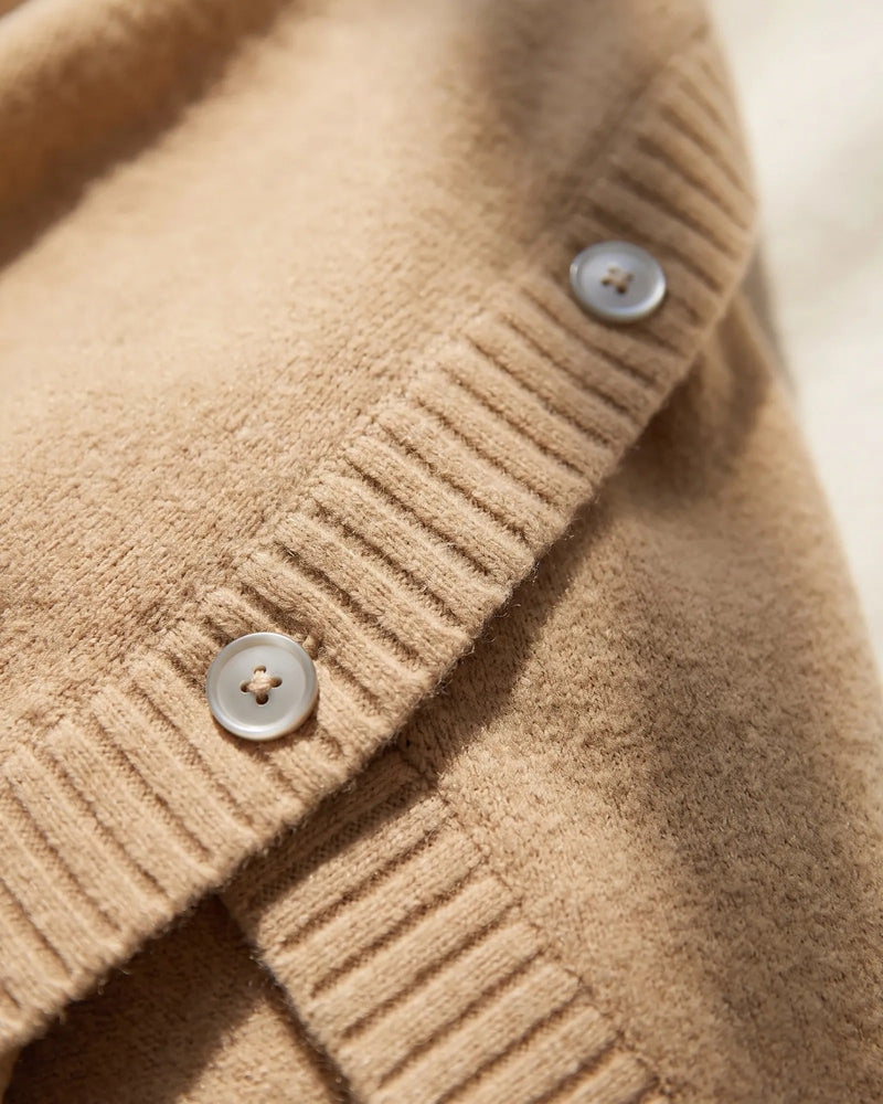 Close view of the ribbed sleeve overlap and a pearl-grey button